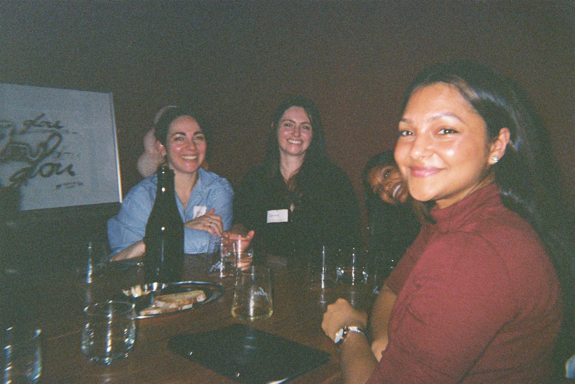 Members smiling together around a table on a night out