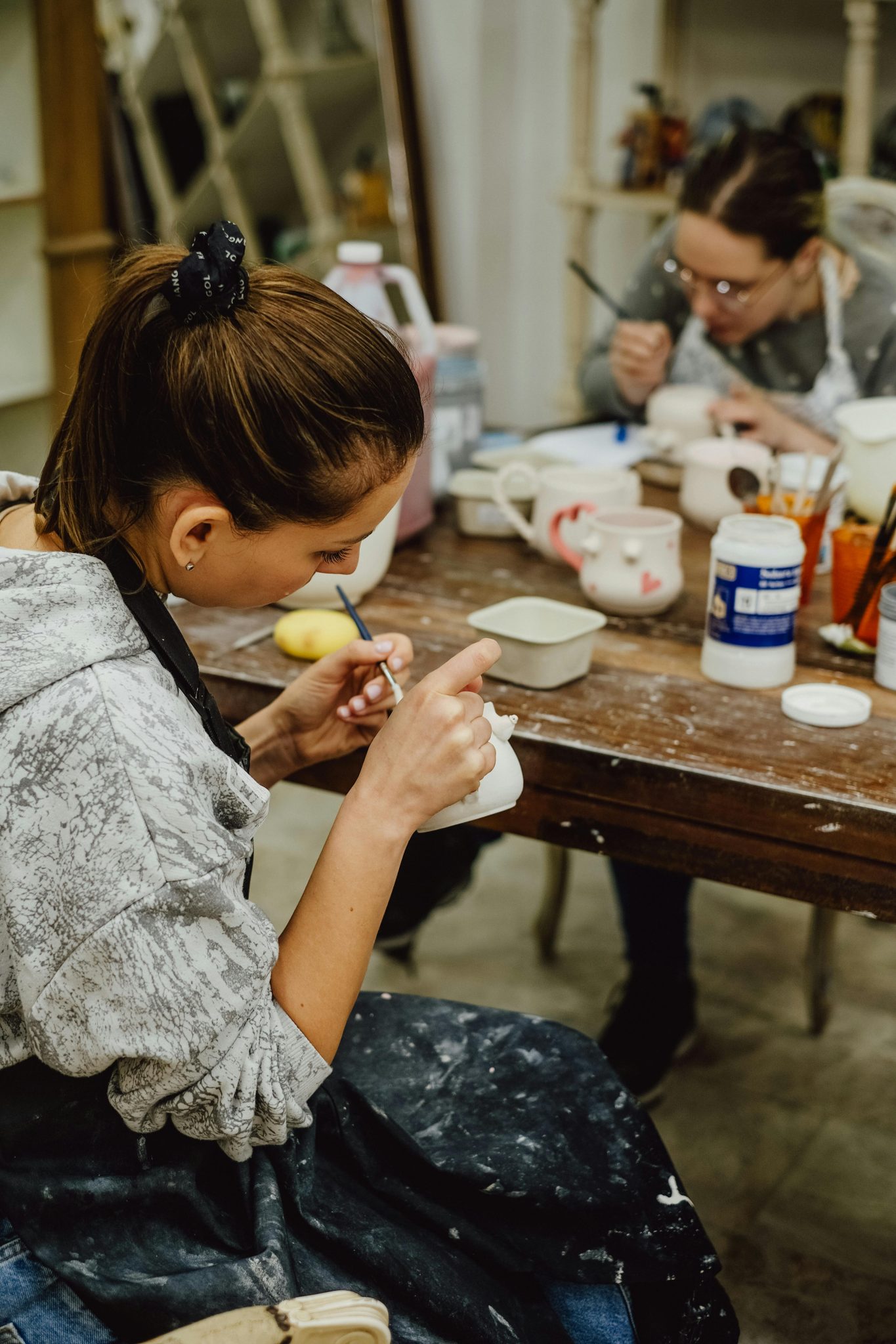 Members painting pottery at an Actually Social crafternoon