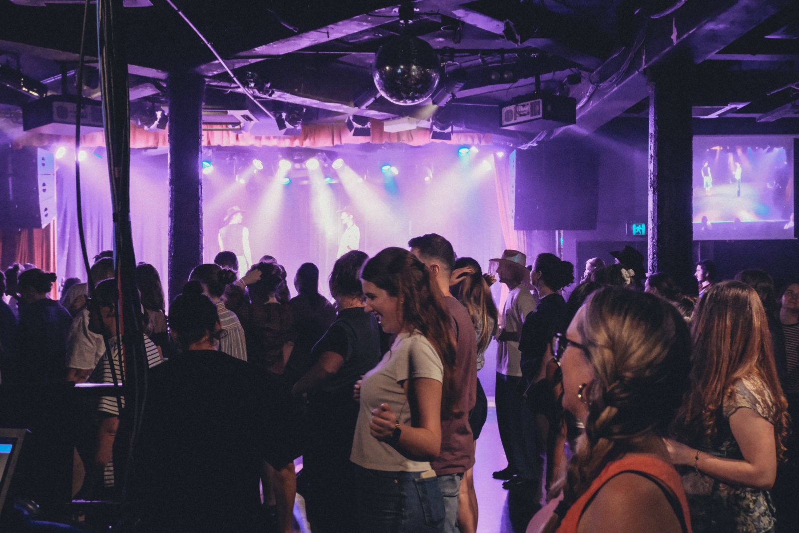 Members dancing under a disco ball on a themed night out
